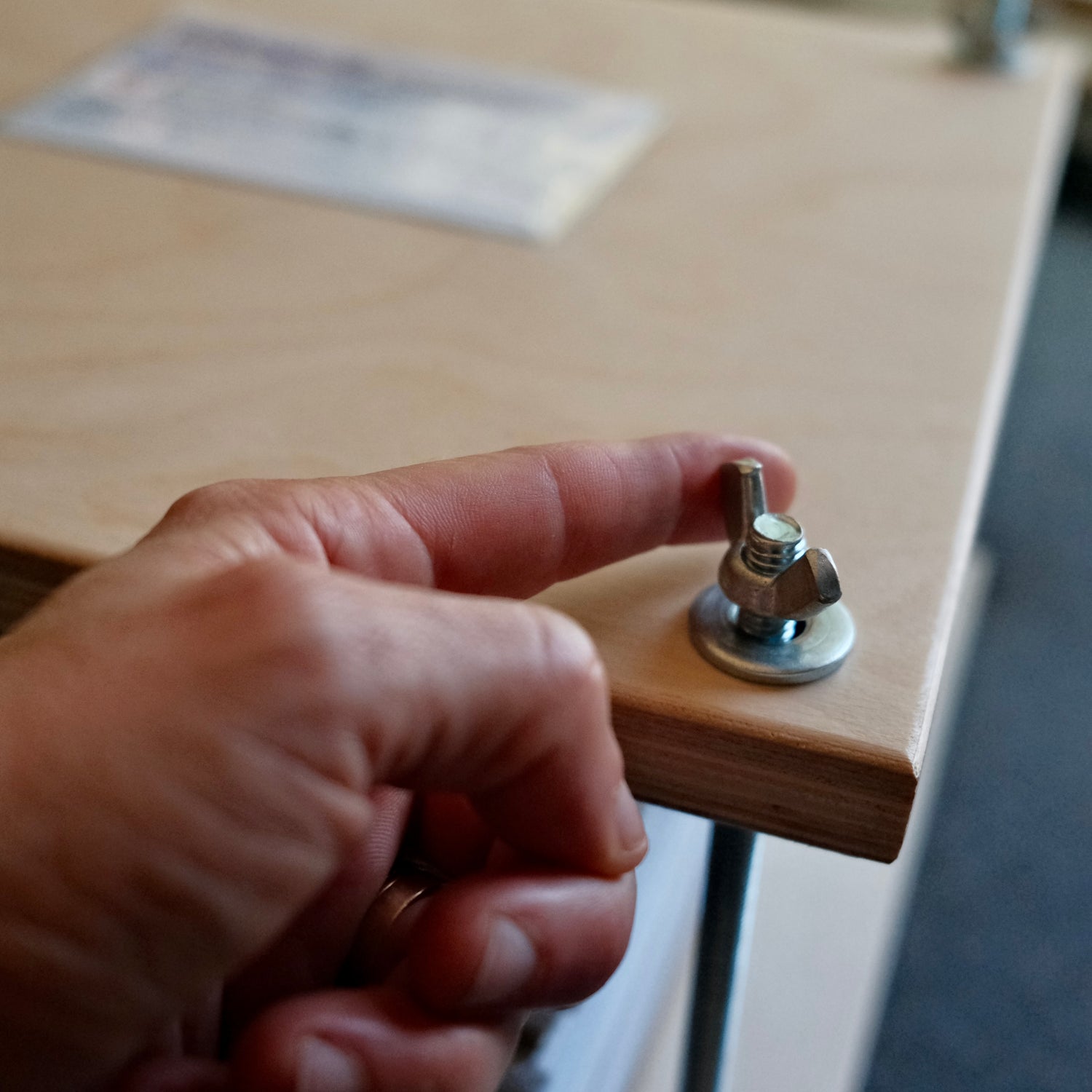 Showing how to tighten a traditional wood flower press using the wingnut.