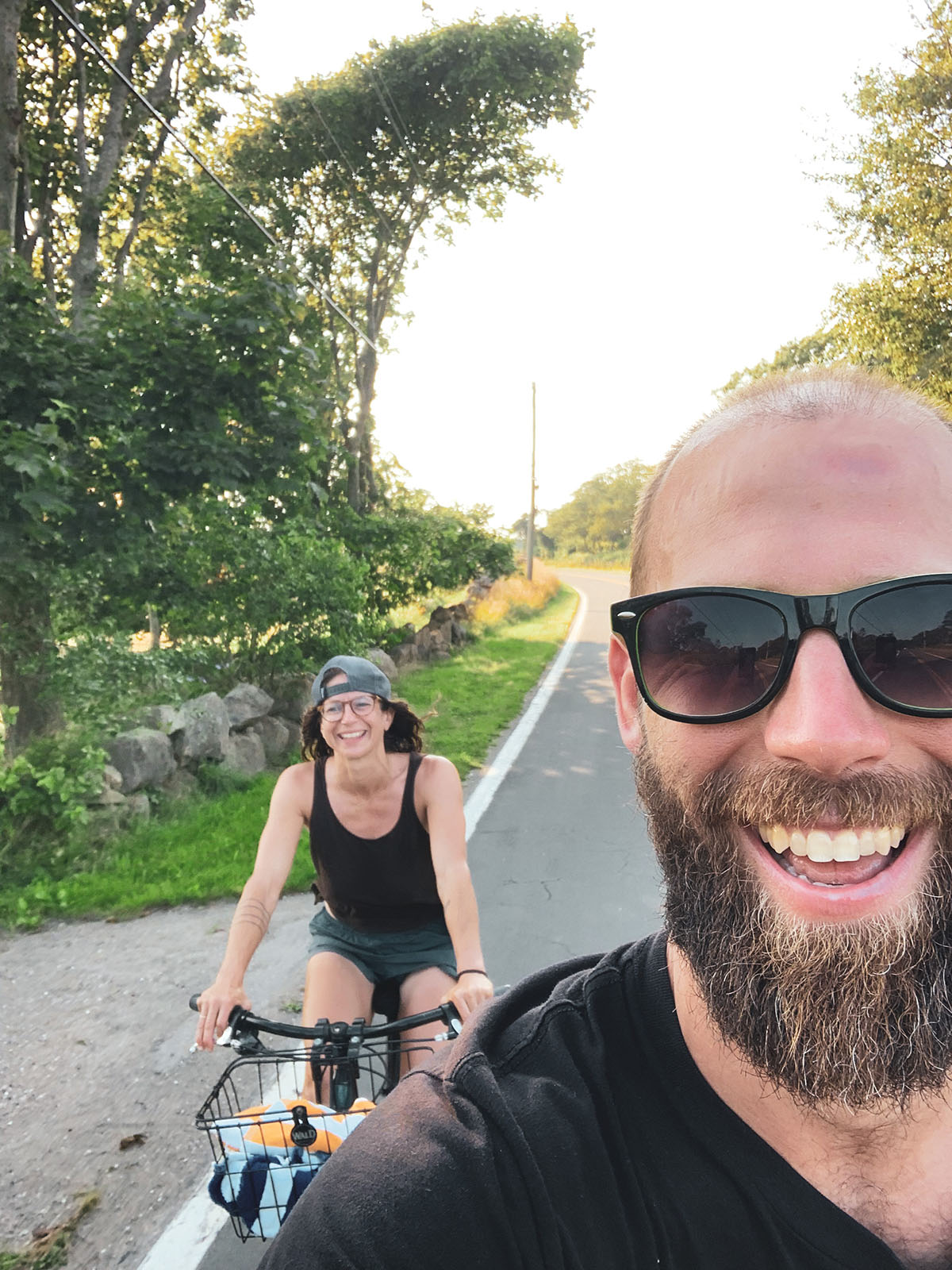 A man and a woman smiling while riding bikes.